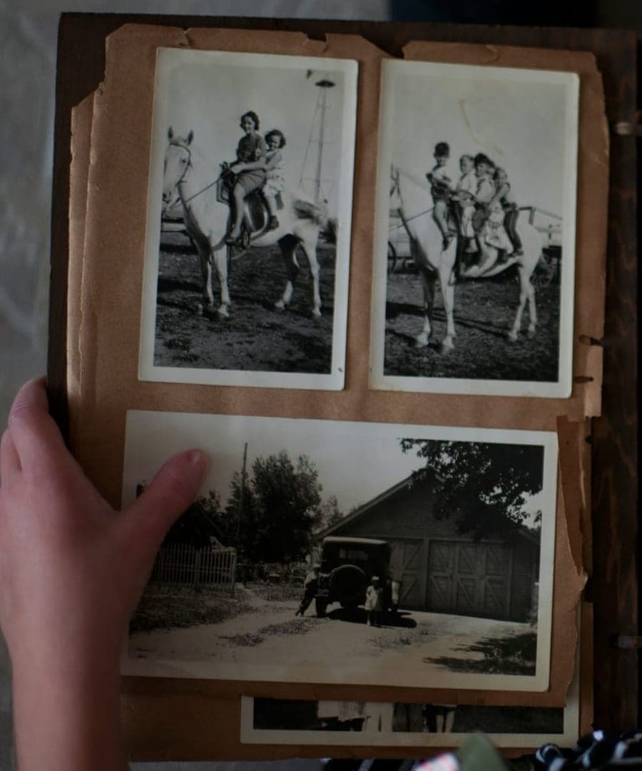 Hand hält ein altes Fotoalbum mit Schwarz-Weiß-Fotos