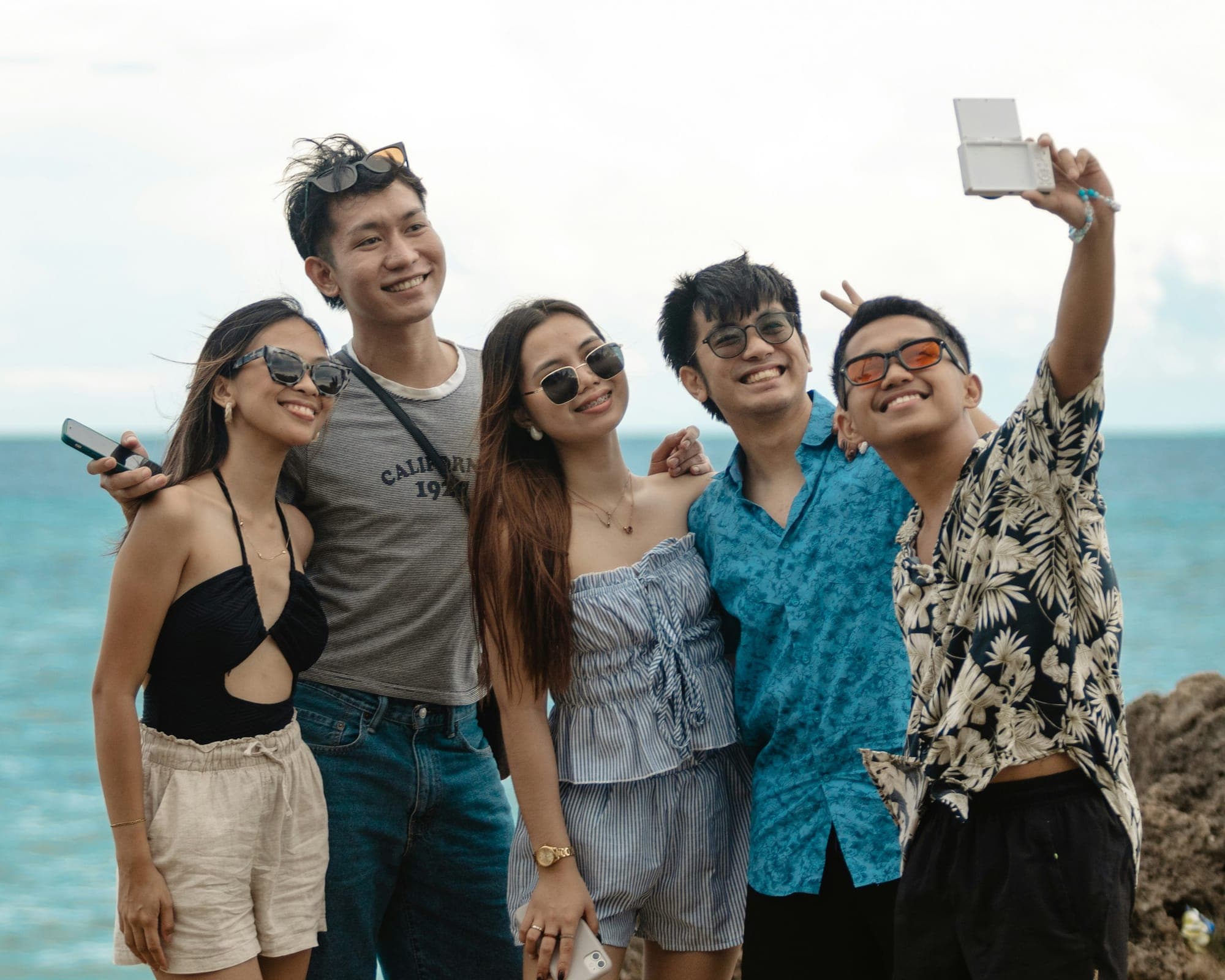 Freundesgruppe macht im Urlaub am Meer ein Gruppenfoto